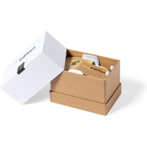 A white box containing a brown cardboard inner box, featuring a wireless charger holder and additional accessories.