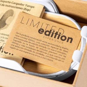 A white charger holder with a natural wood base, accompanied by a brown card featuring information about a limited edition.