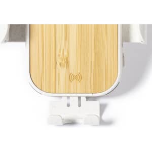 A wireless charger holder with a bamboo top and white base, featuring a logo on the surface.
