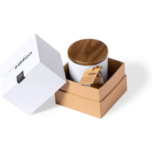 A coffee mug in a white box with a wooden lid, placed inside a brown cardboard box. The mug has a logo.