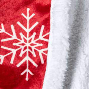 A red blanket with a white snowflake pattern and a soft white fleece edge.