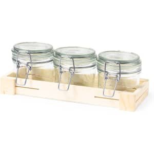 Three glass jars with metal clips, housed in a wooden tray. Clear glass and natural wood tones feature prominently.
