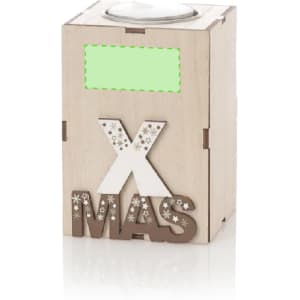 A wooden candle holder featuring a silver lid and the letters "XMAS" in a decorative design. It has a logo on the front.
