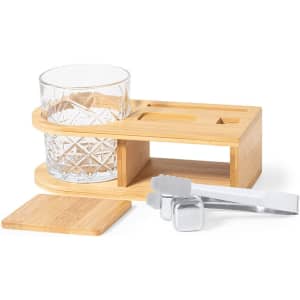 A whisky set featuring a crystal glass, bamboo tray, stainless steel tongs, and ice cubes.
