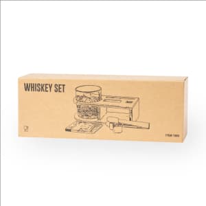 A whiskey set in a cardboard box featuring a glass container and a wooden serving tool, designed in neutral tones.