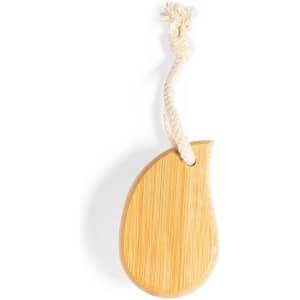 A bamboo face cleansing brush with a beige colour and a rope loop for hanging. It features a smooth, curved shape.