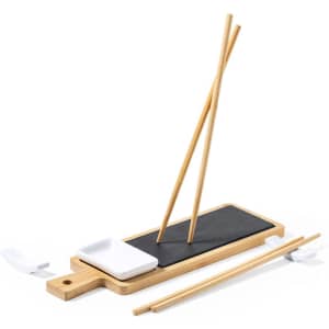 A bamboo sushi set featuring chopsticks, a serving board, and a small dish, with a black and white colour scheme.