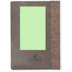 A grey notepad with a textured brown fabric spine and a green decorative section, featuring a logo at the bottom.