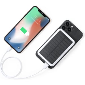 A power bank with solar panel features, connected to a smartphone displaying a low battery. The power bank is sleek and black.
