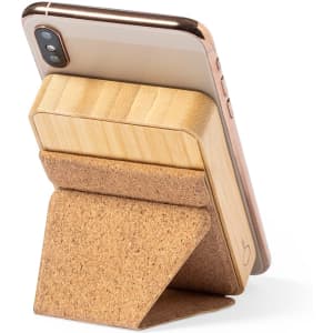 A phone stand made of bamboo and cork, holding a smartphone in an upright position. It features a logo.