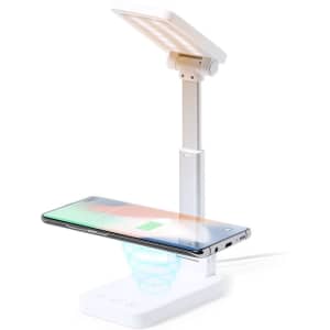 A white multifunction lamp with an adjustable light and a wireless charging pad for smartphones.