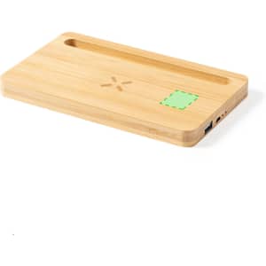 A bamboo wireless charger with an integrated organiser tray, featuring a USB port and a logo.