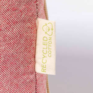 A red and beige laptop pouch with a label indicating it's made from recycled cotton.