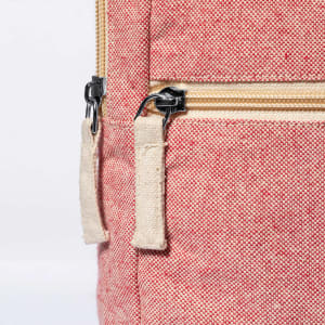 A red document bag features a zip closure and fabric zip pulls. It has a textured finish and a small logo.