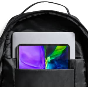 A black backpack with a laptop and tablet visible inside an inner compartment. It has one logo present.