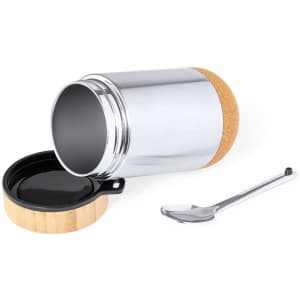 A stainless steel lunch box with a cork bottom and a black lid, accompanied by a metal spoon.