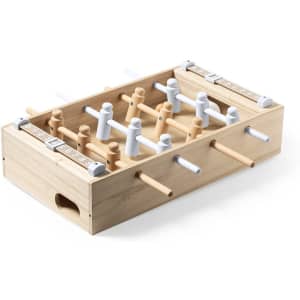 A mini table football game with a wooden base and white plastic player figurines. Features scoring sliders on the side.