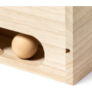 A wooden game piece is partially visible in a slot of a light timber box. The box has a smooth finish and clean lines.