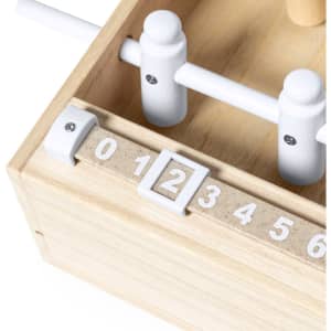 A wooden mini table football game with white players and a score counter featuring numbers from 0 to 6.