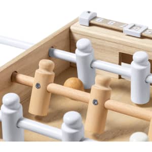 A mini table football game with wooden and white plastic players, featuring a small ball and a score counter.