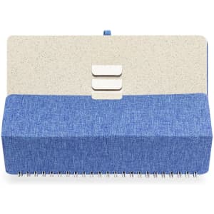 A blue and beige notebook with a textured cover and spiral binding, featuring decorative buttons on the front.