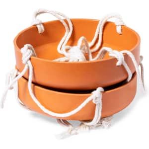 A pair of orange circular bird feeders with white rope handles, designed for outdoor use.
