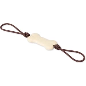 A bone-shaped dog chew toy in cream colour, featuring brown knotted ropes at each end.