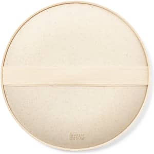 A round, beige game board with a fabric strap, featuring a subtle speckled texture. It has a logo on the surface.