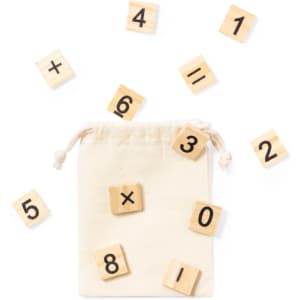 A drawstring bag filled with wooden number tiles in natural wood colour, scattered around the bag.