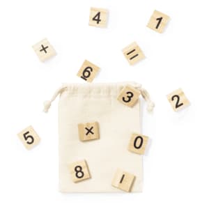 A cream drawstring bag with wooden tiles featuring numbers and mathematical symbols scattered around it.