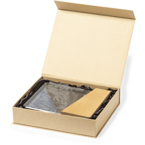 A clear glass plaque and wooden base inside an open box with black filler. The packaging is a light brown.