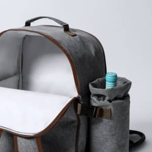 A grey cooler bag backpack with a bottle holder on the side and a spacious interior. It has a logo on the front.
