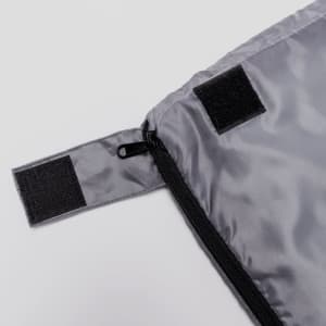 A grey sleeping bag with a zip and Velcro closure detail. Features a smooth, glossy texture.