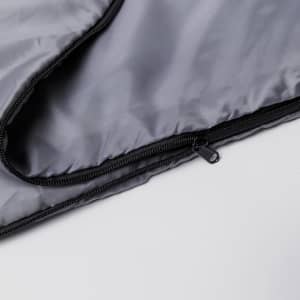 A black sleeping bag with a zipper, featuring a smooth interior and exterior fabric.