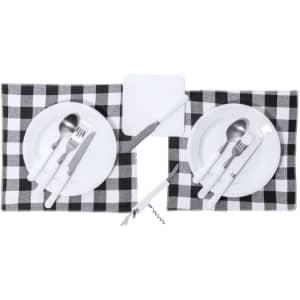 A checkered picnic set featuring white plates, stainless steel cutlery, and a corkscrew on a grey and black placemat.