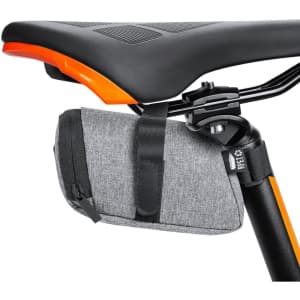 A grey bike bag is attached under a bike saddle with a black strap, featuring a zip closure and a logo.