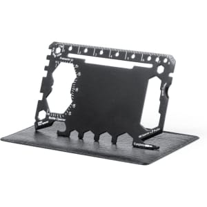 A black multitool with measurement markings, bottle opener, and various tool shapes, displayed on a flat surface.