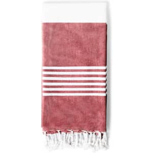 A folded towel in a reddish hue with white stripes and fringe detail at the bottom, featuring a branded logo.