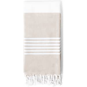 A beige and white towel pareo with striped detailing and tasselled edges, featuring a logo.