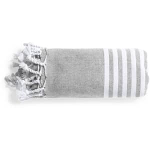 A folded grey towel with white stripes and tassels at one end. It has a simple, textured design.
