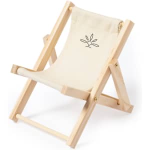 A small wooden phone stand with a cream fabric seat and a simple logo design.