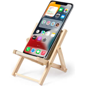 A wooden phone stand in a foldable design, holding a smartphone displaying various apps on the screen.
