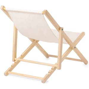 A lightweight folding chair with a natural wooden frame and a cream-coloured fabric seat. It features a minimal design.
