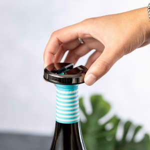 A drink bottle with a black stopper, featuring a turquoise and white striped design on the neck.