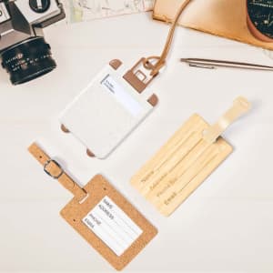 Three luggage tags are displayed: a white tag with brown accents, a cork tag, and a wooden tag, all featuring a branding logo.