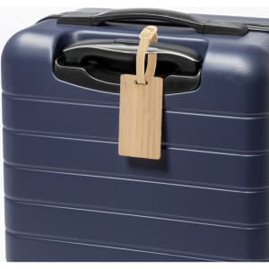 A navy luggage case with a wooden luggage tag attached to the handle. The tag has a simple design and is light in colour.