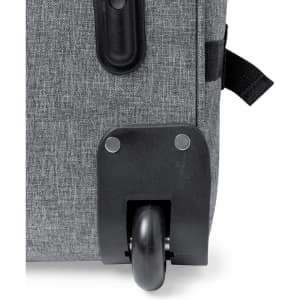 A grey wheeled bag with a smooth black wheel and metal rivets on the bottom edge. It features a textile surface.