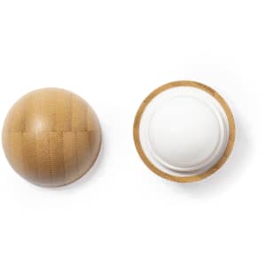 A round lip balm in a natural textured container, featuring a white balm inside. The product has a subtle brown colour.