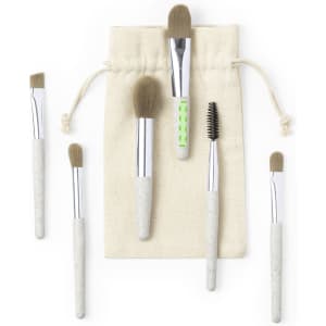 A set of six eyeshadow applicators with cream and green handles, packaged in a cloth pouch.
