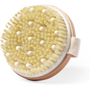 A round exfoliating massage brush with soft bristles and a wooden handle, featuring a convenient strap.